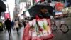Woman walks through Times Square with holiday shopping bags, New York, Dec. 2, 2015.