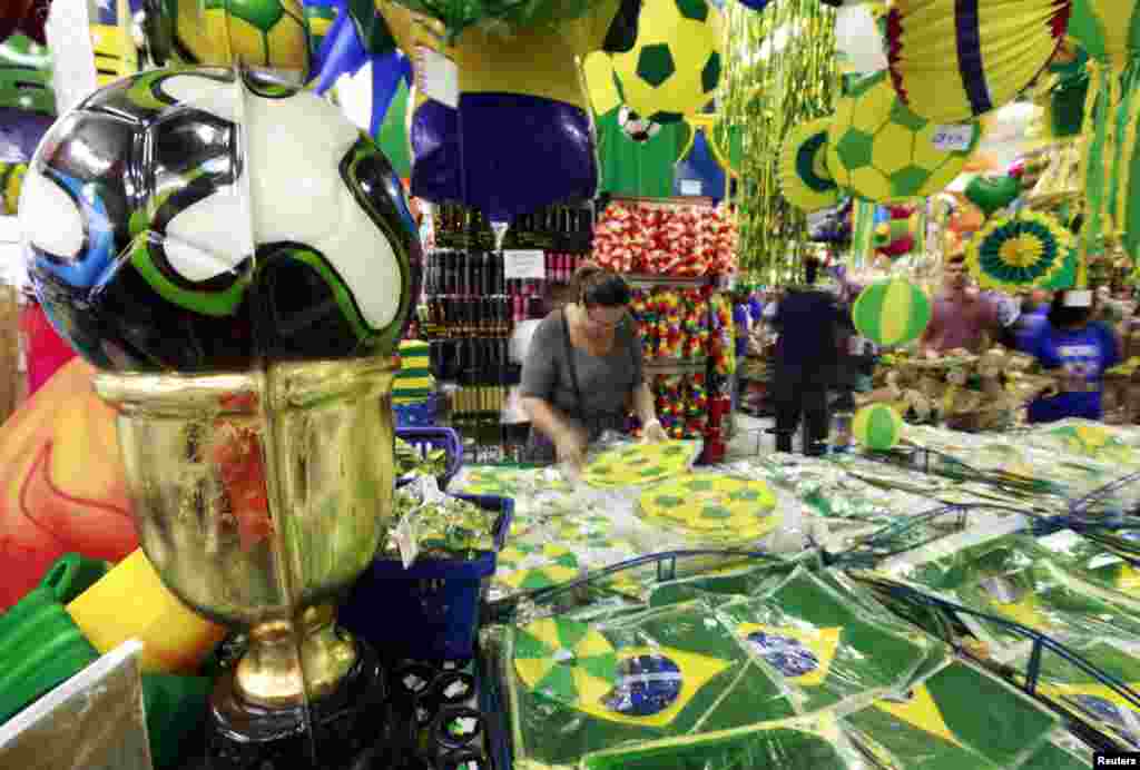 Pessoas procuram recordações do Mundial de Futebol numa loja em São Paulo. O Mundial vai realizar-se no Brasil entre 12 de Junho e 13 de Julho. Maio 7, 2014. 
