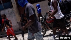 Sejumlah anak-anak tampak menemani anggota geng bersenjata dalam sebuah aksi protes di wilayah Delmas, di Port-au-Prince, Haiti, pada 10 Mei 2024. (Foto: Reuters/Pedro Valtierra Anza)