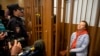 Sutradara teater terkemuka Rusia Zhenya Berkovich duduk di dalam sel di ruang pengadilan pada persidangan kasusnya yang digelar di Moskow, Rusia, pada 5 Mei 2023. (Foto: AP/Alexander Zemlianichenko)