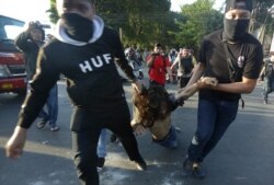 FILE - Plain-clothed police officers arrest a student protester during a rally in Makassar, South Sulawesi province, Indonesia, Sept. 26, 2019.