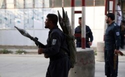 FILE - Afghan security personnel stand guard after the offices of Amrullah Saleh was targeted in a deadly attack, in Kabul, Afghanistan, July 28, 2019.