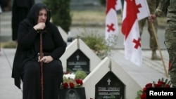 Seorang perempuan meratapi kuburan seorang prajurit Georgia yang tewas saat konflik antara Georgia dan Rusia di Ossetia selatan pada tahun 2008. (Foto: dok.)