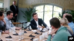 FILE - Ukrainian President Volodymyr Zelenskiy speaks with journalists in Kyiv, Ukraine, Oct. 10, 2019. 