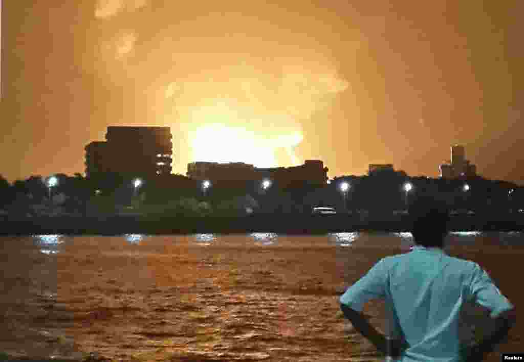 A man watches Indian Navy submarine INS Sindhurakshak on fire, Mumbai, August 14, 2013.