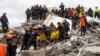 Emergency personnel carry a body during a search for survivors in a collapsed building in Durres, after an earthquake shook Albania, Nov. 28, 2019. 