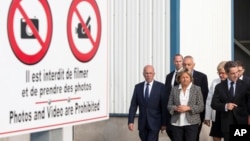 Former French President and candidate for the right-wing Les Republicains party primary Nicolas Sarkozy, right, flanked by Calais Mayor Natacha Bouchart, center, walks during his visit at Calais harbour, northern France, Sept. 21, 2016. 