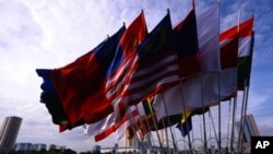 Motorcyclists ride past the flags of participating countries of the ministerial meeting of the Association of Southeast Asian Nations (ASEAN) in Hanoi on July 19, 2009.