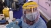 Un agent de santé portant un équipement de protection se prépare à prélever des échantillons au Caire, le 17 juin 2020.