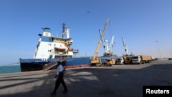 A coast guard walks past a ship docked at the Red Sea port of Hodeida, Yemen, Jan. 5, 2019. 