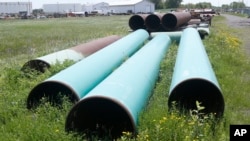 FILE - Pipeline used to carry crude oil is shown at the Superior terminal of Enbridge Energy in Superior, Wis, June 29, 2018. 