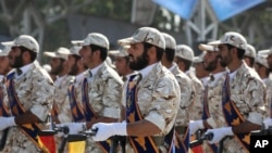 FILE - In this Sept. 22, 2011 photo, members of Iran's Revolutionary Guard march in front of the mausoleum of the late Iranian revolutionary founder Ayatollah Khomeini, just outside Tehran.