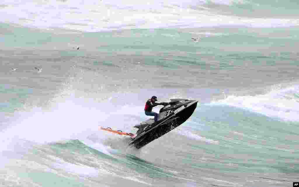 Seorang petugas penyelamat mengendarai jet ski untuk mencari seorang perenang Jepang yang hilang saat berenang di Pantai Bondi, Sydney, Australia.