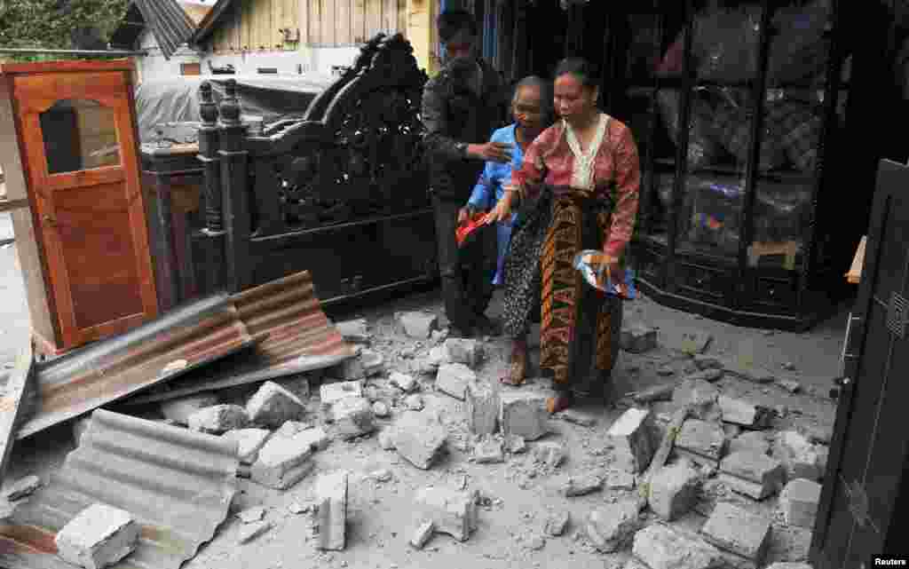Residents leave their house after it was hit by a strong earthquake in Bener Meriah district in Central Aceh, July 2, 2013.