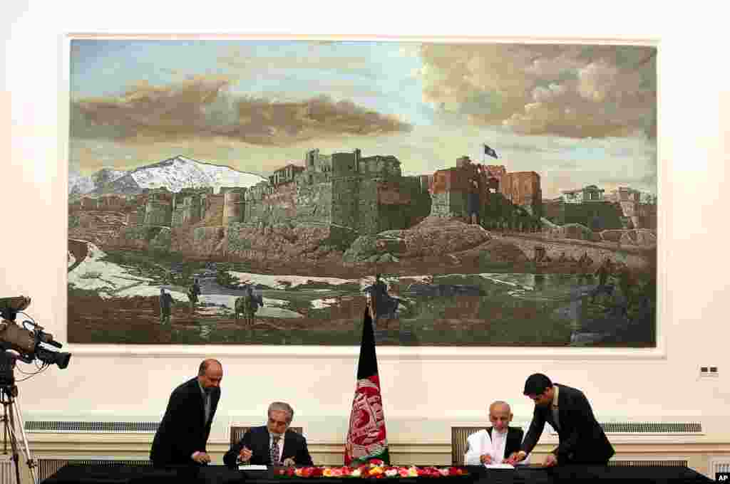 Abdullah Abdullah and Ashraf Ghani Ahmadzai sign a power-sharing deal at the presidential palace in Kabul, Afghanistan, Sept. 21, 2014.