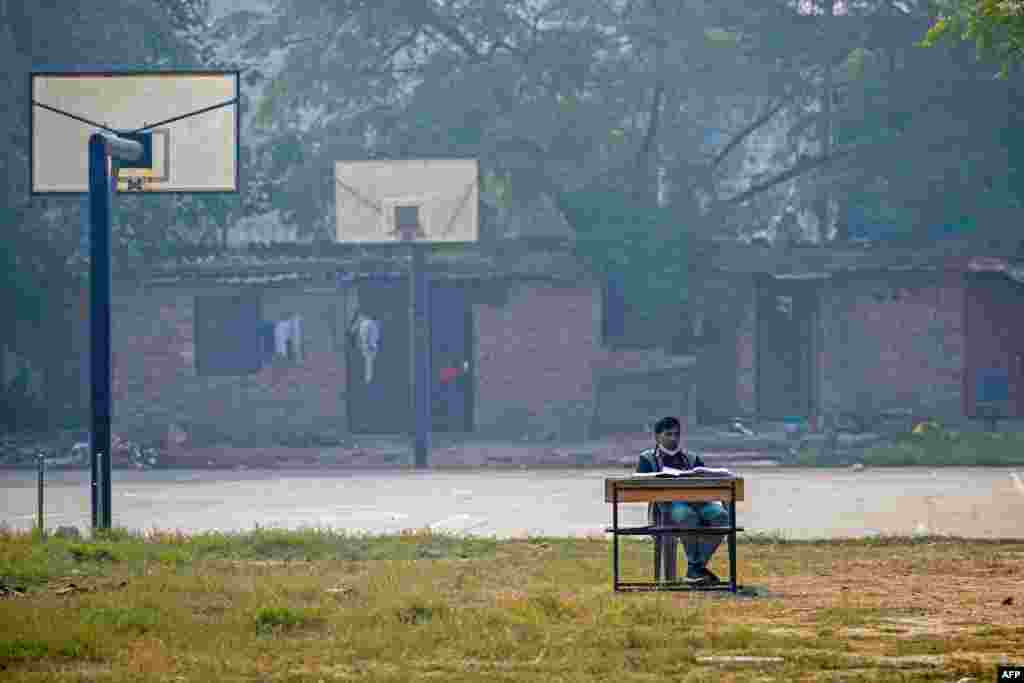 A school teacher conducts an online class near a basketball court at Swami Sivananda Memorial Institute in New Delhi. Keeping children at home and moving lessons online for days at a time during the peak of the smog crisis has become an annual ritual in the area. 