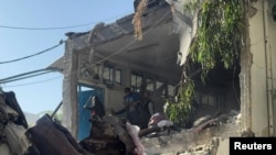 গাজা সিটির এক আশ্রয় কেন্দ্রে ইসরায়েলি হামলার পর ফিলিস্তিনিরা ক্ষয়ক্ষতি পর্যবেক্ষণ করছে। ফটোঃ ২৭ সেপ্টেম্বর, ২০২৪