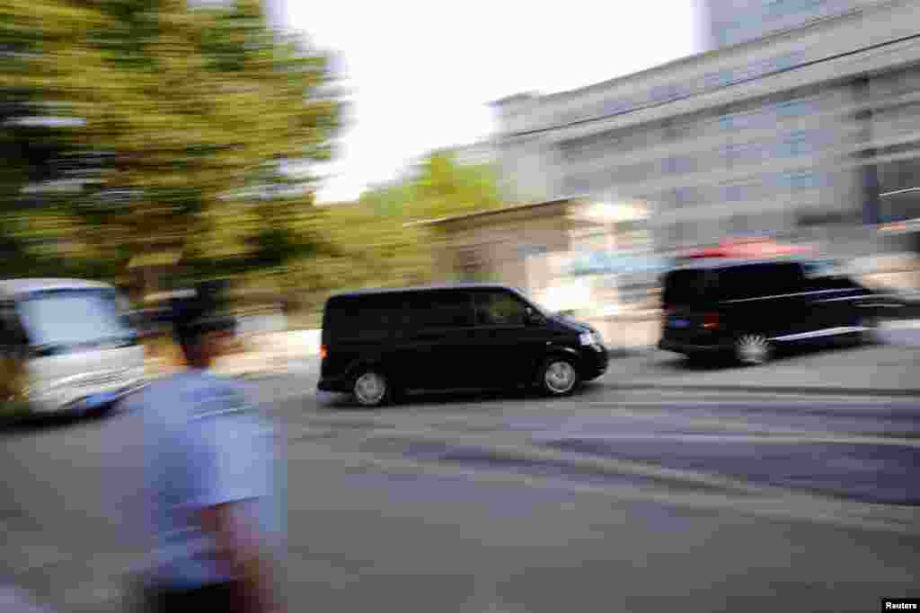 A minivan (C) believed to be carrying disgraced Chinese politician Bo Xilai arrives at the Jinan Intermediate People's Court ahead of the fifth day of Bo's trial in Jinan, Shandong province, August 26, 2013. 