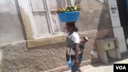 "Zungueira" com o filho nas costas