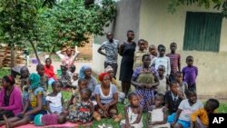 Relatives of the 5-year-old boy who became Ebola's first cross-border victim, and others, listen as village leaders and health workers educate them about Ebola, in Kirembo, Uganda, June 15, 2019. 