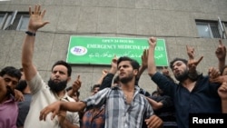 Demonstrators shout slogans outside a hospital emergency unit during a protest against the Indian government's scrapping of Kashmir's special status, in Srinagar, Aug. 9, 2019.