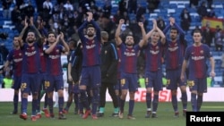 Barcelona’s Gerard Pique and teammates applaud the fans at the end of the club's soccer match with Real Madrid in Madrid, Dec. 23, 2017.