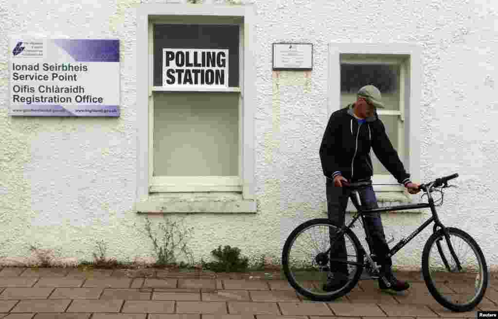 Seorang pria tiba di tempat pemungutan suara di Portree, Pulau Skye (18/9). (Reuters/Cathal McNaughton)