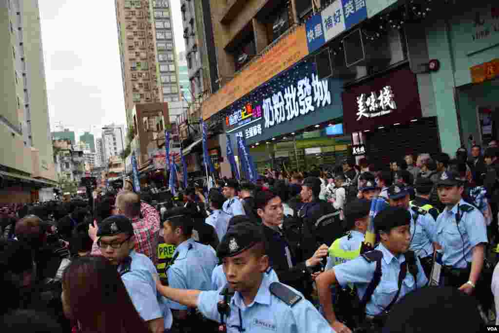 大批示威者在元朗奶粉城及一間經常有水貨客光顧的食品店門外聚集,兩間店舖暫停營業,警員在場維持秩序。(美國之音湯惠芸攝)