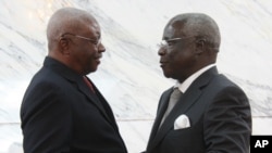 Mozambique President Arnando Guebuza, left, and former Renamo rebel leader Afonso Dhlakama, right, shake hands after signing a peace accord, Sept. 5, 2014. 