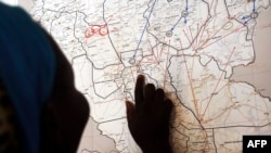 FILE - Evalina, a South Sudanese teenage victim of sexual abuse, points on a map to Unity state, indicating where she used to live, March 9, 2015. She said she escaped to Khartoum after being imprisoned by gunmen and sexually abused for two months.