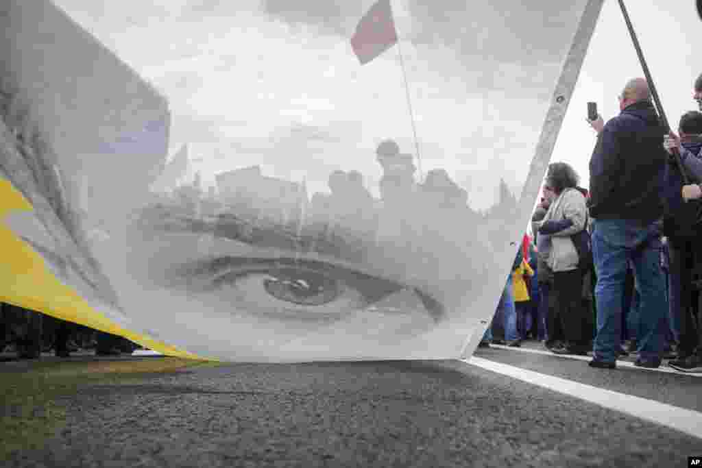 Protesters hold a poster with the image of political prisoner Oleg Sentsov during an opposition rally organized by 'Free Russia' in Moscow, Russia.