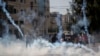 Palestinian protesters run for cover from tear gas fired by Israeli soldiers during clashes with Israeli troops near Ramallah, West Bank, Oct. 17, 2015.