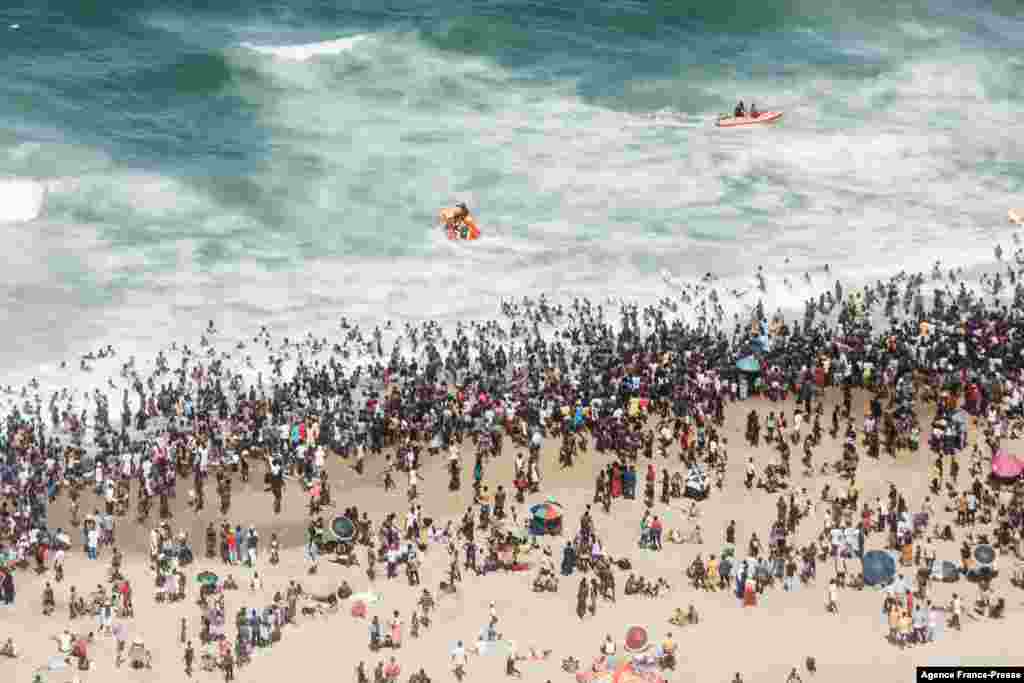 Thousands of New Year's day revelers and holidaymakers gather on the North Pier Beach during New Year festivities in Durban, South Africa, Jan. 1, 2022, after the government lifted a COVID-19 restriction.