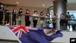 Waandamanaji wakiimba "Glory to Hong Kong" and na kupeperusha bendera katika eneo la biashara mjini Hongo Kong, Ijumaa, Mei 29, 2020.