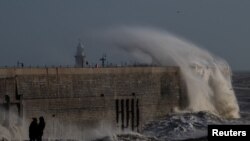 Penduduk setempat menyaksikan angin kencang akibat Badai Bert menyebabkan ombak menerjang pelabuhan di Folkestone, Inggris, 24 November 2024.