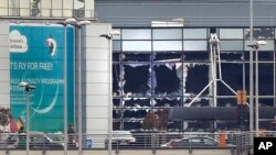 FILE - Broken windows are seen at the scene of explosions at the Brussels airport, Belgium, March 22, 2016. 