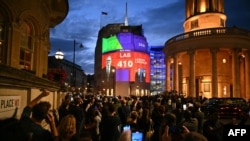 Hasil japat keluar TPS (exit poll) pemilu Inggris yang menunjukkan kemenangan Partai Buruh ditampilkan di layar yang terpasang di gedung BBC Broadcasting House di London, Kamis, 4 Juli 2024. (Foto: Oli Scarff/AFP)