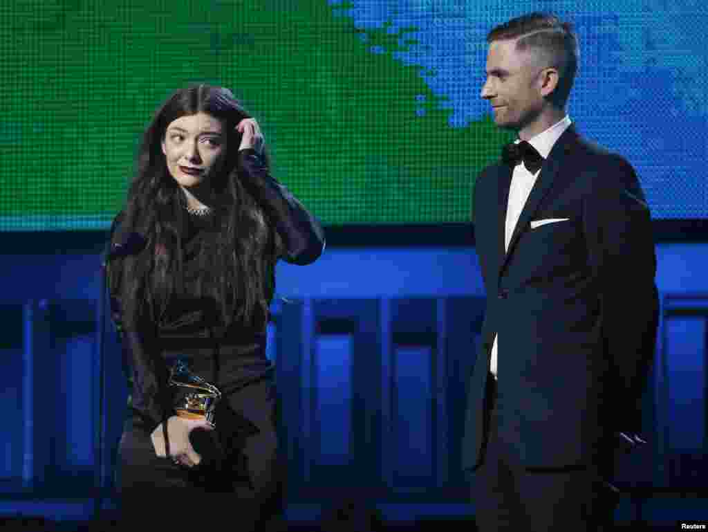Lorde is accompanied by producer Joel Little after they won the award for Song of the Year for "Royals" at the 56th annual Grammy Awards in Los Angeles, Jan. 26, 2014.