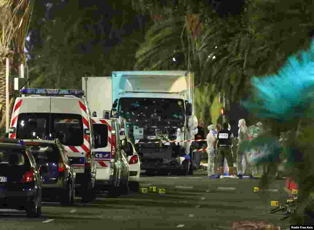 French police forces and forensic officers stand next to a truck July 15, 2016, that ran into a crowd celebrating the Bastille Day national holiday on the Promenade des Anglais in Nice, France, July 14.