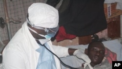 A health worker examines a man suffering from Ebola at a treatment center in Monrovia, Liberia, Wednesday, Oct. 15, 2014. Some doctors in countries hit hardest by the deadly Ebola disease decline to operate on pregnant women for fear the virus could spread. Governments face calls from frightened citizens to bar travel to and from the afflicted region. Meanwhile, the stakes get higher as more people get sick, highlighting a tricky balance between protecting people and preserving their rights in a global crisis. (AP Photo/Abbas Dulleh)