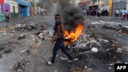 ARCHIVO: Un hombre pasa junto a una barricada en llamas durante una protesta contra el primer ministro haitiano, Ariel Henry, pidiendo su renuncia, en Puerto Príncipe, Haití, el 10 de octubre de 2022.