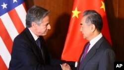 FILE - Menteri Luar Negeri AS Antony Blinken (kiri), dan Menteri Luar Negeri China Wang Yi berjabat tangan saat pertemuan mereka di Konferensi Keamanan Munich, di Munich, Jerman, 16 Februari 2024. (Wolfgang Rattay/Pool Photo via AP)