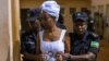 Diane Shima Rwigara escortée par des policières dans une salle d'audience à Kigali, au Rwanda, le 11 octobre 2017.
