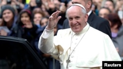 Pope Francis waves as he leaves at the end of his mass at the Church of the Most Holy Name of Jesus in Rome, Jan. 3, 2014. 