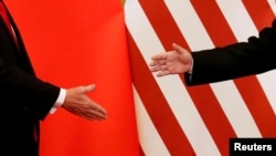 美国总统特朗普和中国国家主席习近平在北京人民大会堂发表联合声明后握手。（2017年11月9日）