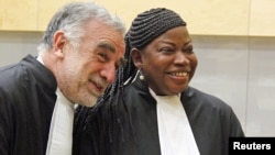 Newly sworn-in ICC prosecutor Fatou Bensouda shares a laugh with her predecessor Luis Moreno-Ocampo (L) at the ICC, The Hague, Netherlands, June 15, 2012. 