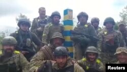 烏克蘭國防部發布的視頻截圖顯示烏克蘭軍人站在據說位於哈爾科夫地區的烏俄邊界。(2022年5月15日)