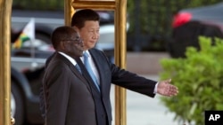 FILE - In this file photo taken on Aug. 25, 2014, Chinese President Xi Jinping, right, shows Zimbabwe's President Robert Mugabe the way during a welcome ceremony outside the Great Hall of the People in Beijing, China.
