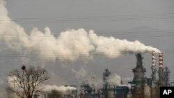 FILE - Smoke and steam rise from a coal processing plant that produces carbon black, an ingredient in steel manufacturing, in Hejin in central China's Shanxi Province, Nov. 28, 2019. 