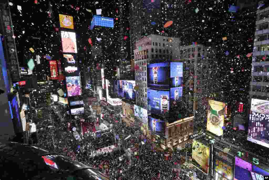 Confetti drops over the crowd as the clock strikes midnight during the New Year's celebration in Times Square as seen from the Marriott Marquis in New York, Monday, Jan. 1, 2018. (AP Photo/Seth Wenig)